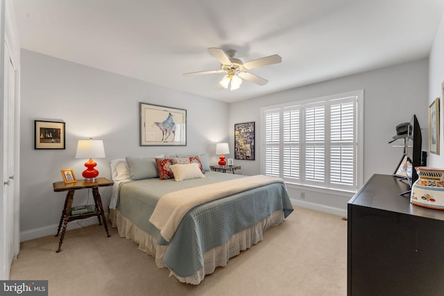 bedroom with light colored carpet, a ceiling fan, and baseboards