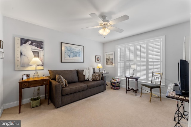 carpeted living room featuring baseboards and ceiling fan