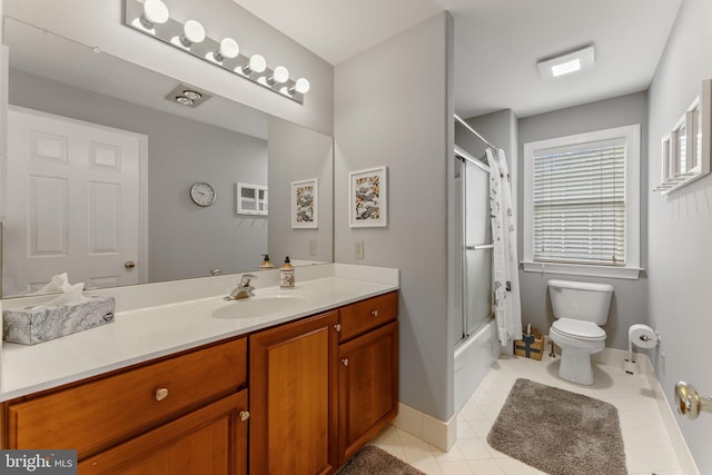 bathroom with toilet, enclosed tub / shower combo, tile patterned flooring, baseboards, and vanity