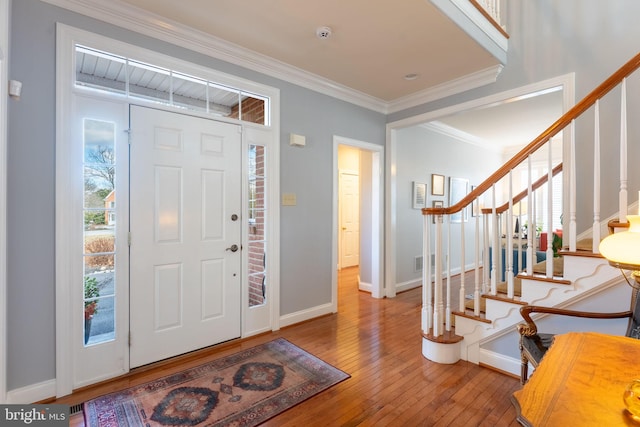 entryway featuring stairs, baseboards, wood-type flooring, and crown molding