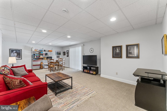 living room with a drop ceiling, recessed lighting, baseboards, and carpet