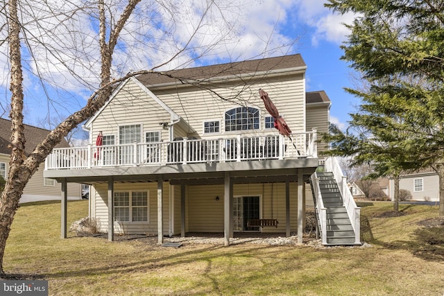 back of property with a wooden deck, a lawn, and stairs