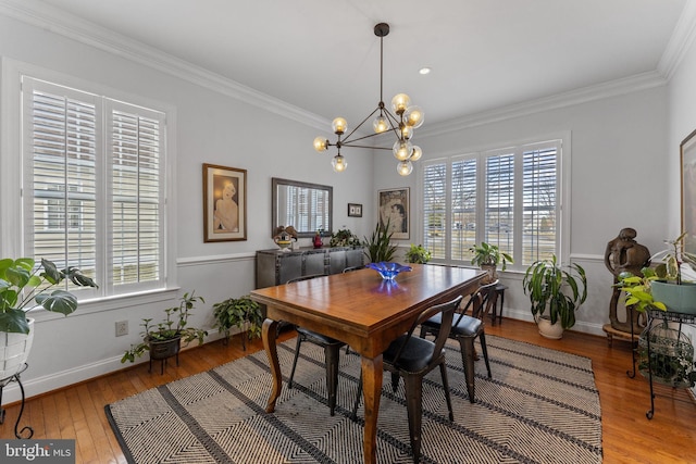 dining space featuring plenty of natural light, crown molding, and hardwood / wood-style flooring