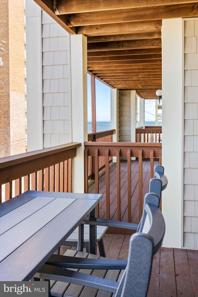 wooden terrace with outdoor dining space and a water view