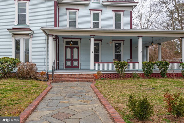 view of front of home featuring covered porch and a front lawn