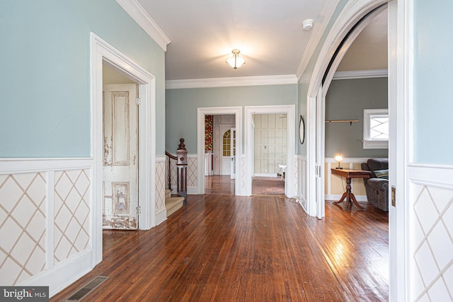 foyer featuring visible vents, arched walkways, ornamental molding, and stairway