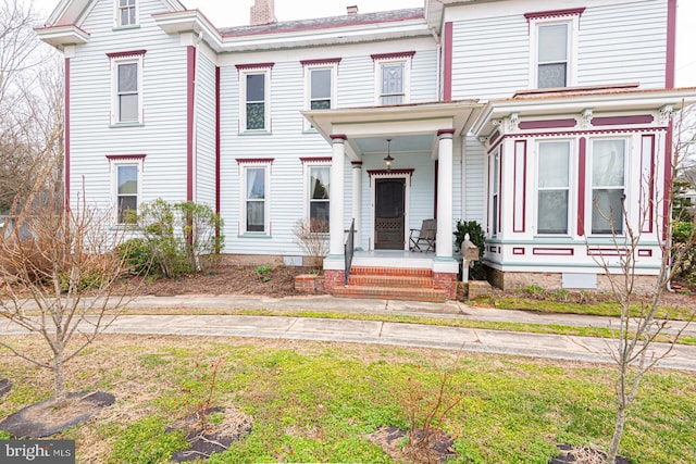 view of front of home with a porch and a chimney