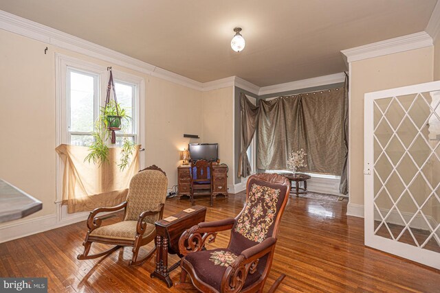 sitting room featuring hardwood / wood-style floors, baseboards, and ornamental molding