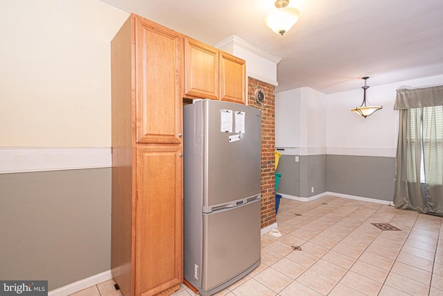 kitchen with light tile patterned floors, freestanding refrigerator, baseboards, and decorative light fixtures