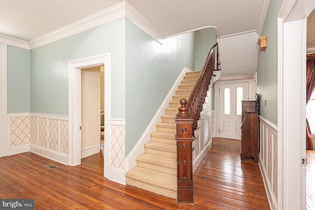 foyer featuring a wainscoted wall, stairs, and hardwood / wood-style flooring