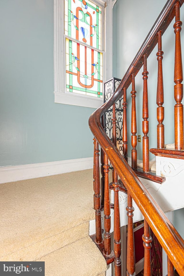 staircase featuring carpet and baseboards