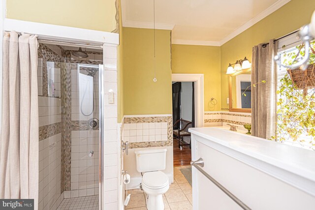 full bathroom with ornamental molding, a shower stall, wainscoting, tile walls, and tile patterned floors