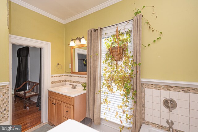 full bathroom with a wealth of natural light, tile walls, vanity, and crown molding