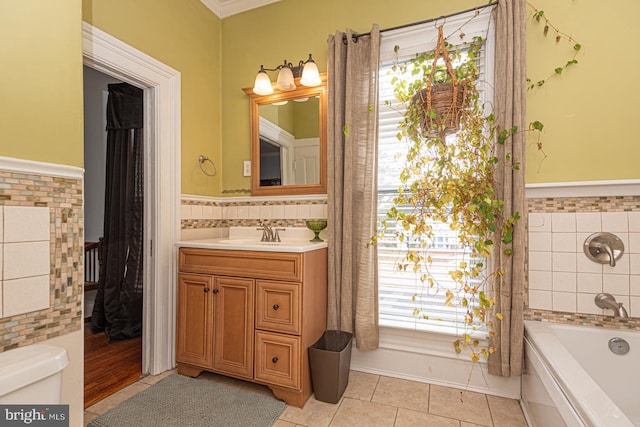 full bathroom with a bathing tub, tile walls, vanity, and tile patterned flooring