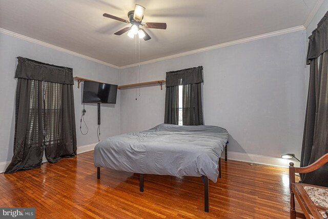 bedroom with ceiling fan, crown molding, baseboards, and hardwood / wood-style floors