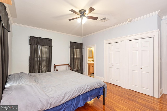 bedroom featuring a ceiling fan, visible vents, a closet, crown molding, and light wood-type flooring