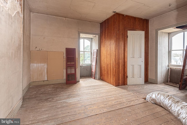 unfurnished room featuring wooden walls and wood-type flooring