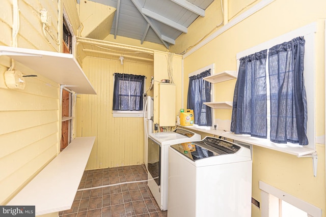 laundry room with washing machine and dryer, laundry area, and wood walls