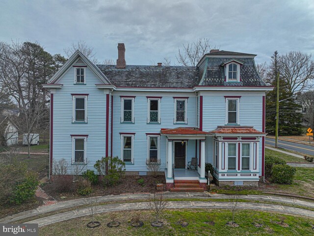 view of front of house featuring mansard roof and a chimney