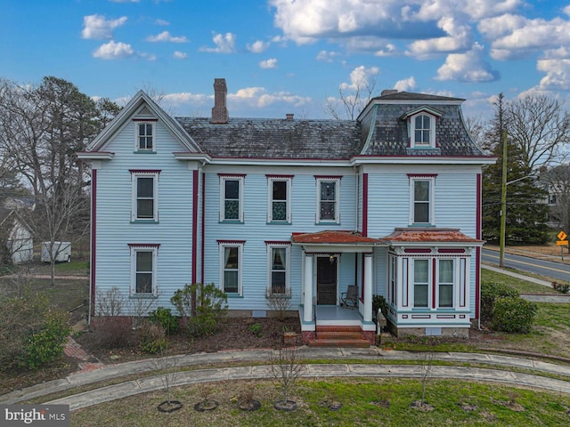 view of front of property with mansard roof and a chimney