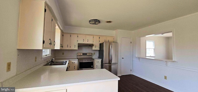 kitchen with under cabinet range hood, light countertops, ornamental molding, stainless steel appliances, and a sink