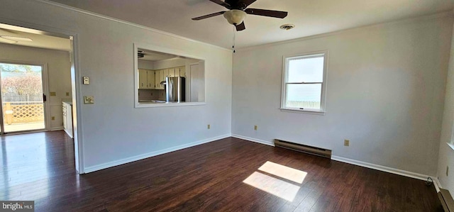 empty room featuring dark wood finished floors, a healthy amount of sunlight, a baseboard heating unit, and ceiling fan