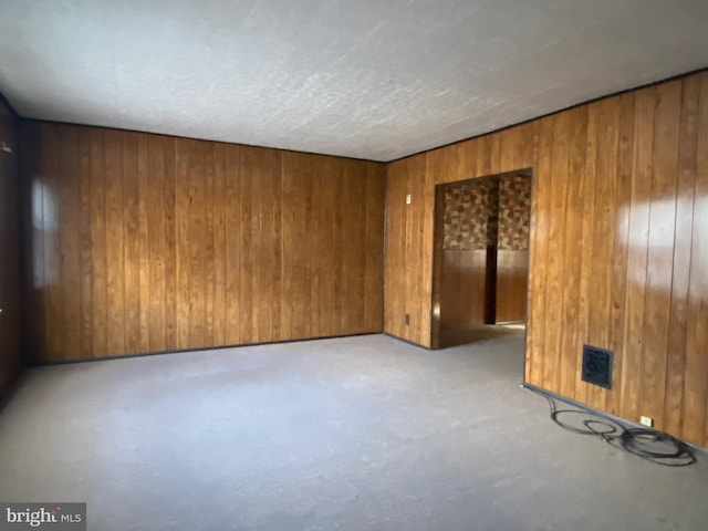 unfurnished room with wood walls and concrete floors