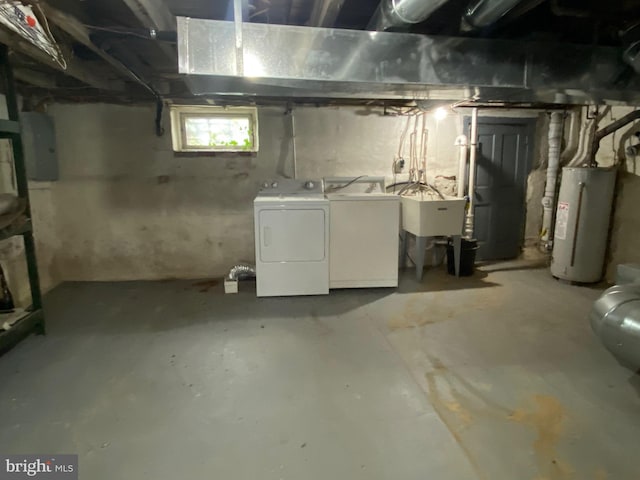 below grade area featuring a sink, washing machine and dryer, and water heater