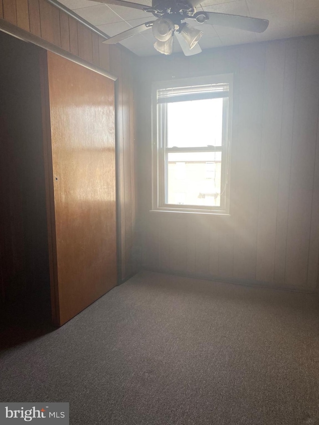 carpeted empty room with a ceiling fan