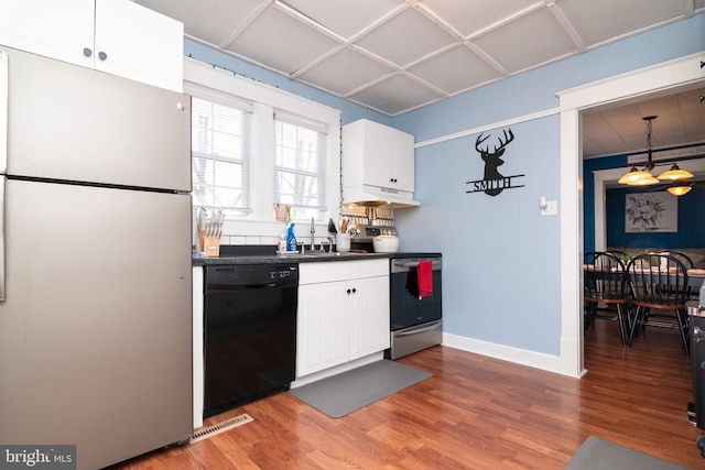 kitchen featuring stainless steel appliances, dark countertops, white cabinets, and light wood finished floors