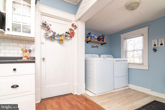 laundry room with washer and clothes dryer, laundry area, baseboards, and light wood-style floors