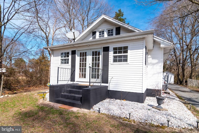 view of side of home featuring an outdoor structure and french doors