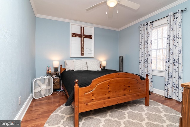 bedroom featuring ceiling fan, crown molding, baseboards, and wood finished floors