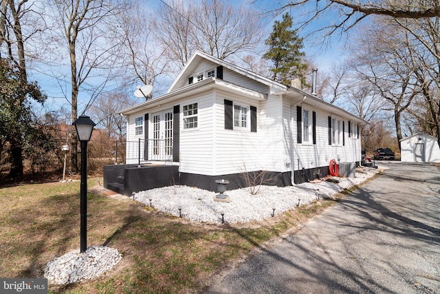 view of property exterior with driveway and an outdoor structure