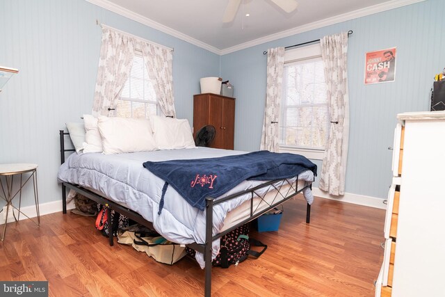 bedroom featuring ceiling fan, crown molding, baseboards, and wood finished floors