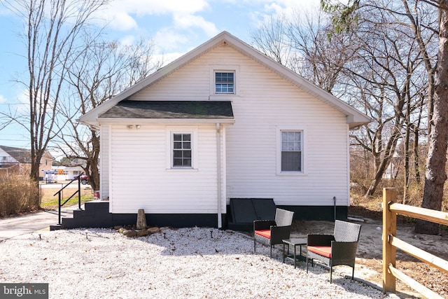 rear view of house with roof with shingles