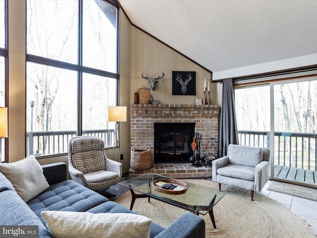 living area featuring tile patterned flooring, high vaulted ceiling, a brick fireplace, and a textured ceiling