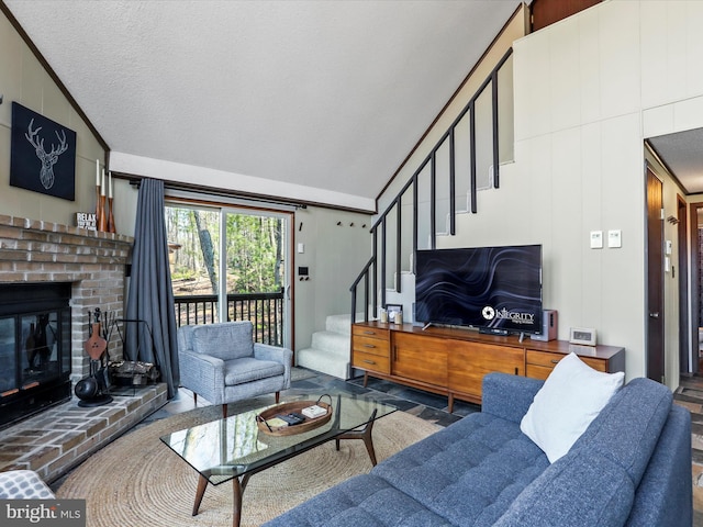 living room featuring stairs, lofted ceiling, a fireplace, and a textured ceiling