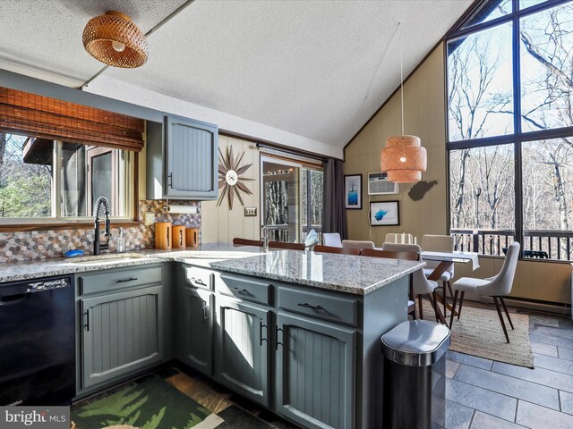 kitchen featuring a peninsula, gray cabinetry, a sink, dishwasher, and tasteful backsplash