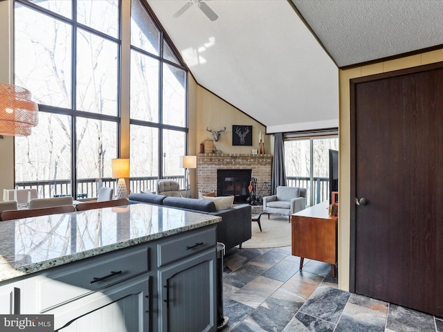 kitchen featuring a wealth of natural light, gray cabinets, ceiling fan, and a fireplace