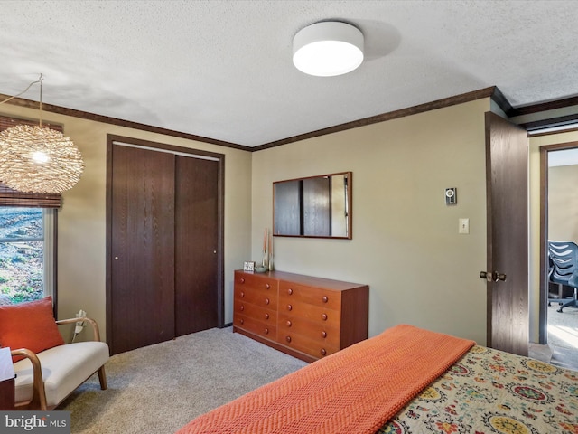 carpeted bedroom with ornamental molding, a closet, and a textured ceiling