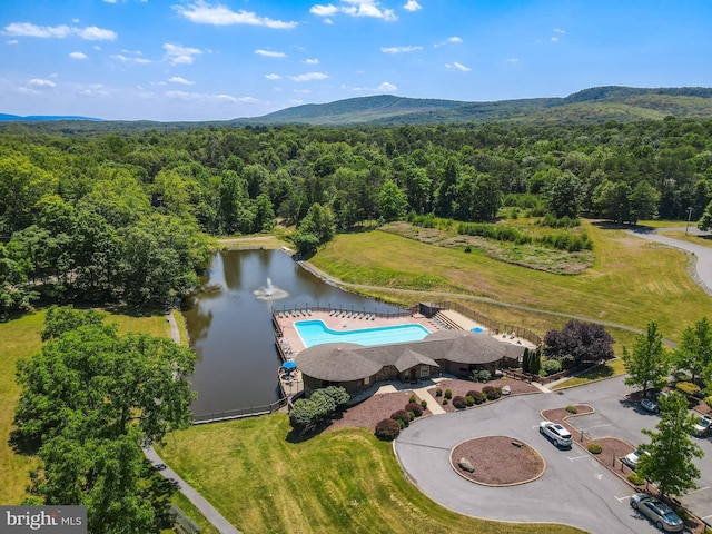 drone / aerial view featuring a water and mountain view and a wooded view