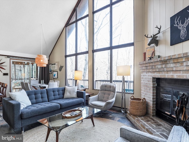 living area featuring high vaulted ceiling and a brick fireplace