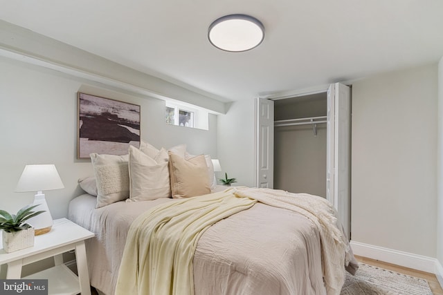 bedroom featuring a closet, baseboards, and wood finished floors