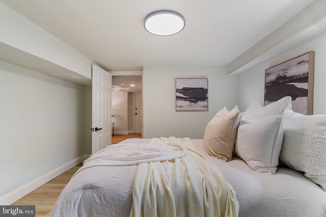 bedroom with light wood finished floors and baseboards