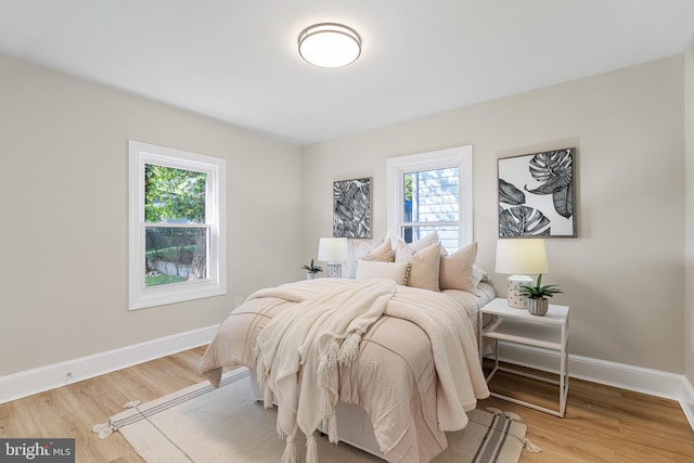 bedroom with light wood-style floors and baseboards