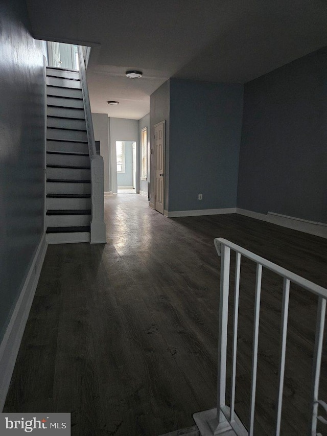 hallway with stairway, baseboards, and wood finished floors