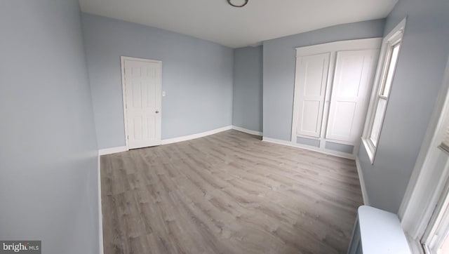 unfurnished bedroom featuring baseboards and wood finished floors