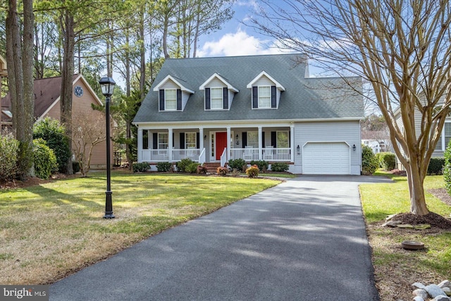 new england style home featuring driveway, a front lawn, a porch, roof with shingles, and a garage