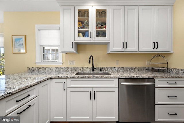 kitchen featuring a sink, light stone counters, white cabinetry, glass insert cabinets, and dishwasher